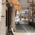 Sunlit street featuring a vintage cafe and bicycle, capturing a charming urban vibe.